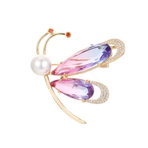 Broche papillon dorée élégante avec des gemmes dégradées et une perle blanche centrale