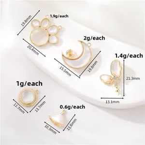 Detail of 14K gold-plated shell charms including cat paw and moon shapes for DIY jewelry