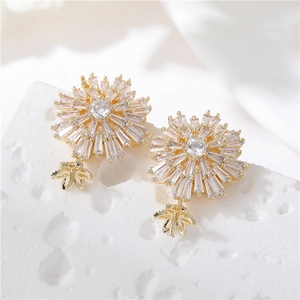 Elegantes pendientes de flores doradas con circonitas brillantes en base de piedra blanca