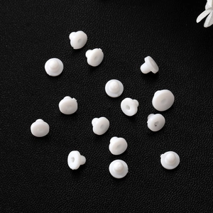 White silicone flying saucer ear nuts for stud earrings on black leather surface
