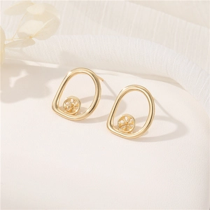 Orecchini a goccia minimalisti placcati oro 14k su una superficie elegante e strutturata