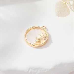 Macro detail of 14K gold plated sun pendant with white shell and zircon on stone background