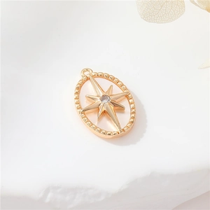 Macro detail of 14K gold-plated oval star pendant with white shell and zircon inlay