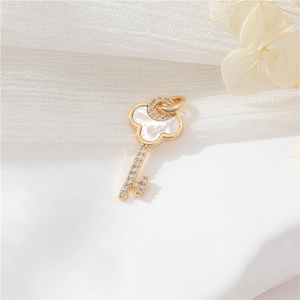 Detail of 14k gold-plated clover key pendant with white mother of pearl and zircons
