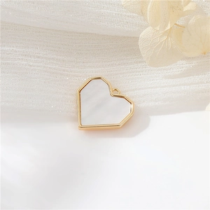 Detail of 14k gold-filled heart pendant with white mother of pearl inlay for jewelry making
