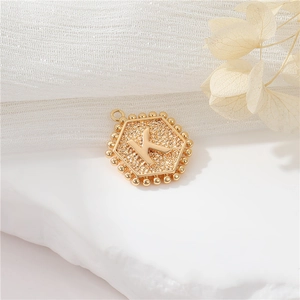 Elegant gold hexagon initial K pendant with beaded edge on a minimalist white background