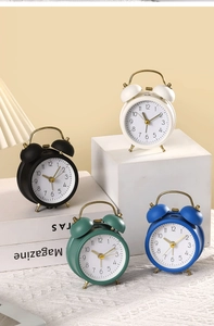 Detailed view of retro metal twin bell alarm clocks in white, black, green and blue colors