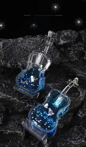 Detail of violin-shaped liquid hourglass with floating astronaut and blue oil drops