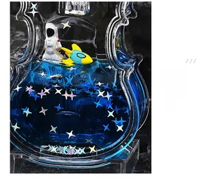 Macro detail of violin-shaped liquid ornament with blue ocean fluid and astronaut models