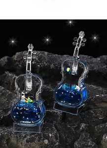 Luminous blue liquid cello ornament with astronaut miniatures and silver star sequins