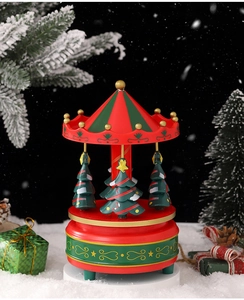 Close-up of a festive Christmas carousel music box with mini trees and snow effects
