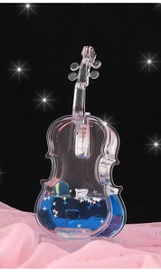 Close-up of violin-shaped liquid desk ornament with blue fluid and floating stars