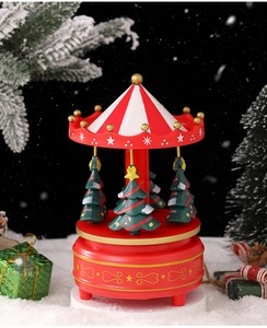 Detail of Christmas carousel music box with mini decorated trees and red gold base