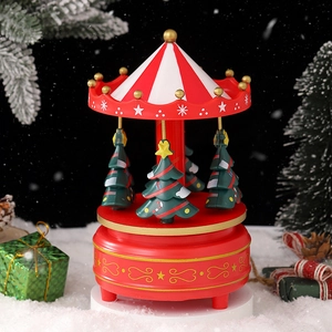 Red and white Christmas carousel music box with mini trees on snowy festive background