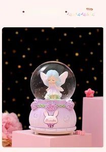 Détail d'une figurine de fée bleue dans une boule à neige musicale violette lumineuse