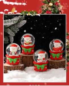 Detailed view of four Santa Claus snow globes with red bases and green bows on wood