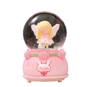 Boule de cristal musicale rose de rêve avec ange aux cheveux d'or et base à relief fleuri