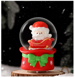 Close-up of Santa Claus in red sleigh inside a glowing Christmas snow globe