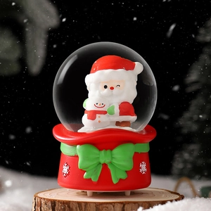 Illuminated Christmas snow globe with Santa and snowman on red base with festive bow