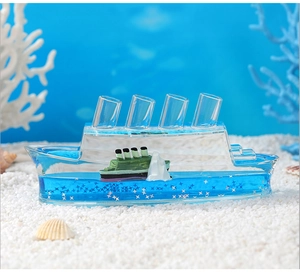 Close-up of Titanic cruise ship fluid drift bottle with blue liquid and white sand décor