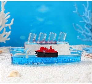 Detail of Titanic fluid bottle with drifting ship and dolphin over decorative white coral