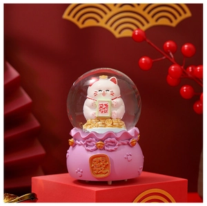 Detail of a lucky cat crystal ball on a red fortune bag base with a Mahjong Fa tile