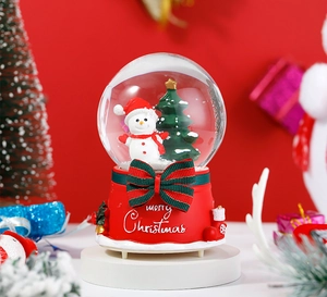 Detail of Santa Claus snow globe with Merry Christmas bow and festive red base