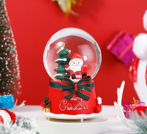 Detail of Santa Claus snow globe with red base and festive Merry Christmas text decoration