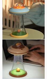 Detailed view of UFO-shaped night lights with cute figures and light beam bases