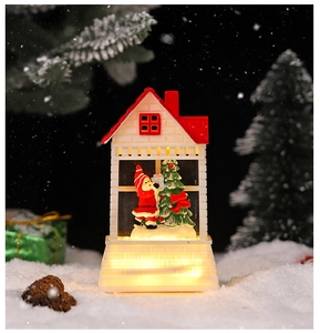 Detail of Christmas lantern with Santa scene and warm LED light in snow