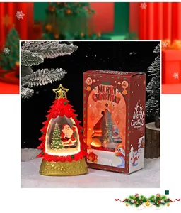 Gros plan d'une boule à neige sapin de Noël avec Père Noël et sa boîte cadeau