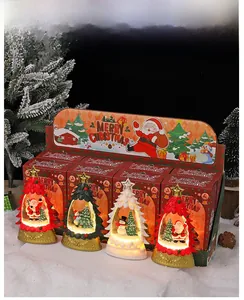 Lanterne de Noël lumineuse avec père Noël et bonhomme de neige dans des coffrets cadeaux rouges