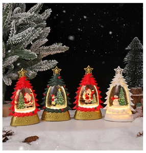 Détail de quatre lampes de Noël en cristal avec lumière chaude et mini figurines de fête