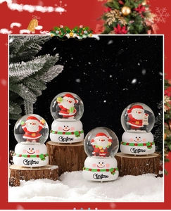 Ensemble de quatre boules à neige Père Noël sur socles bonhommes de neige décoratifs