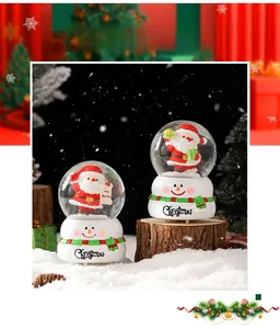 Gros plan de deux boules à neige Père Noël avec socles bonhomme de neige sur fond de fête