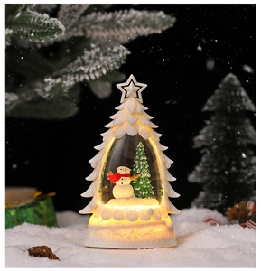 Détail d'une boule à neige bonhomme de neige LED dans un sapin de Noël blanc