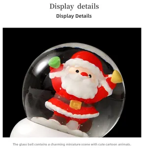 Détail d'une boule à neige de Noël avec Père Noël et socle blanc sur un fond noir contrasté