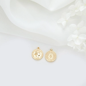 Vista macro de colgantes de moneda 1988 en oro de 14k para joyas DIY y collares