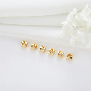 Close-up of 14K gold plated hollow alphabet cubes with numbers and heart for DIY jewelry