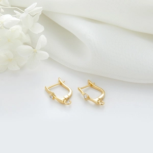 Gros plan boucles d'oreilles dorées avec zircon et boucles pour création de bijoux