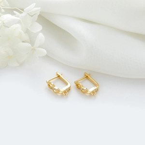 Gros plan sur boucles d'oreilles S925 plaqué or 14K avec design en spirale de zircon
