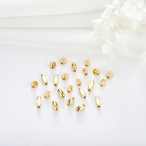 Detailed macro of gold-plated copper cylinder beads and diverse geometric spacer beads