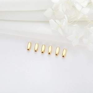 Polished gold-plated copper tube beads for DIY bracelet jewelry making on white fabric
