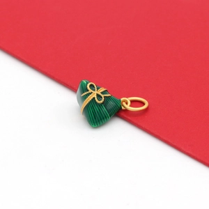 Detail van een groene zongzi-hanger met goudkleurige knoop en ringetje