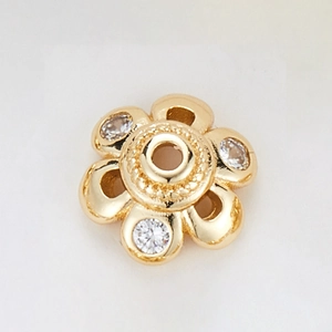 Macro detail of 14k gold plated flower bead spacer with zircons and central hole