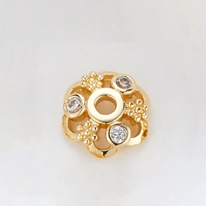 Detailed macro view of 14k gold-plated flower bead cap spacer with cubic zirconia
