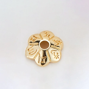 Macro view of 14k gold-plated flower spacer bead with engraved religious characters