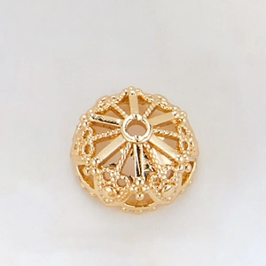 Detailed view of 14k gold-plated hollow floral bead cap with embossed radial patterns