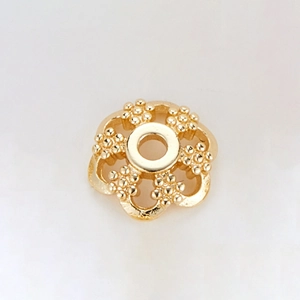 Macro detail of 14k gold plated five-petal flower bead cap with textured surface and center hole