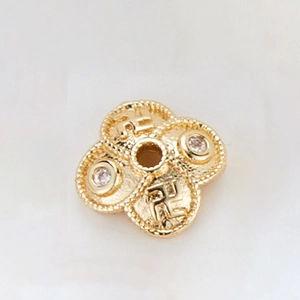 Macro shot of 14k gold plated hollow flower spacer bead with zircon and religious symbols